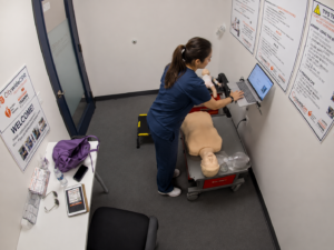 Healthcare professional completing online BLS coursework on a laptop before an American Heart Association hands-on skills session.