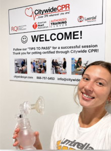 Participant holding CPR ventilation equipment inside a Citywide CPR Self-Guided Skills Session training room.