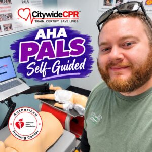 Participant at a Citywide CPR training station with pediatric CPR manikin and AHA PALS Self-Guided certification graphic.